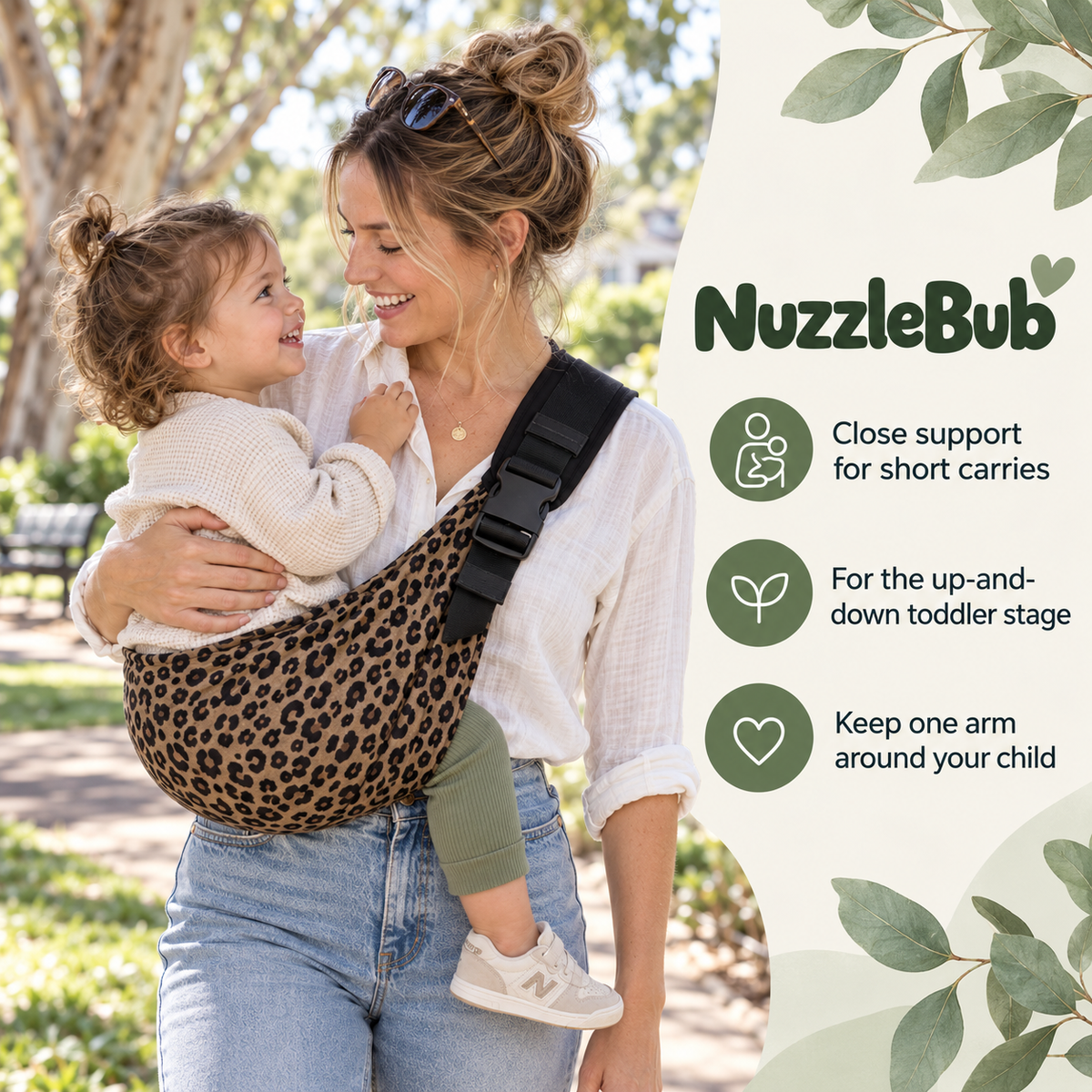 Parent supporting a toddler in the leopard-print NuzzleBub Hip Sling